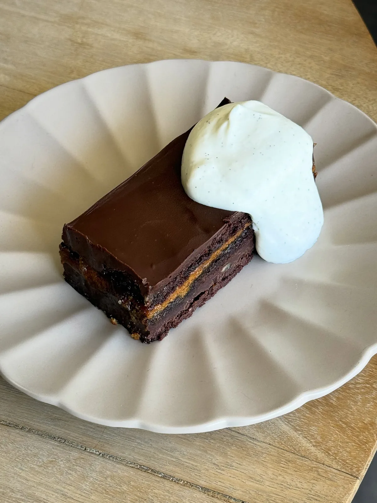 Pastel de chocolate de Pig’s Pearls con crema servido en plato blanco